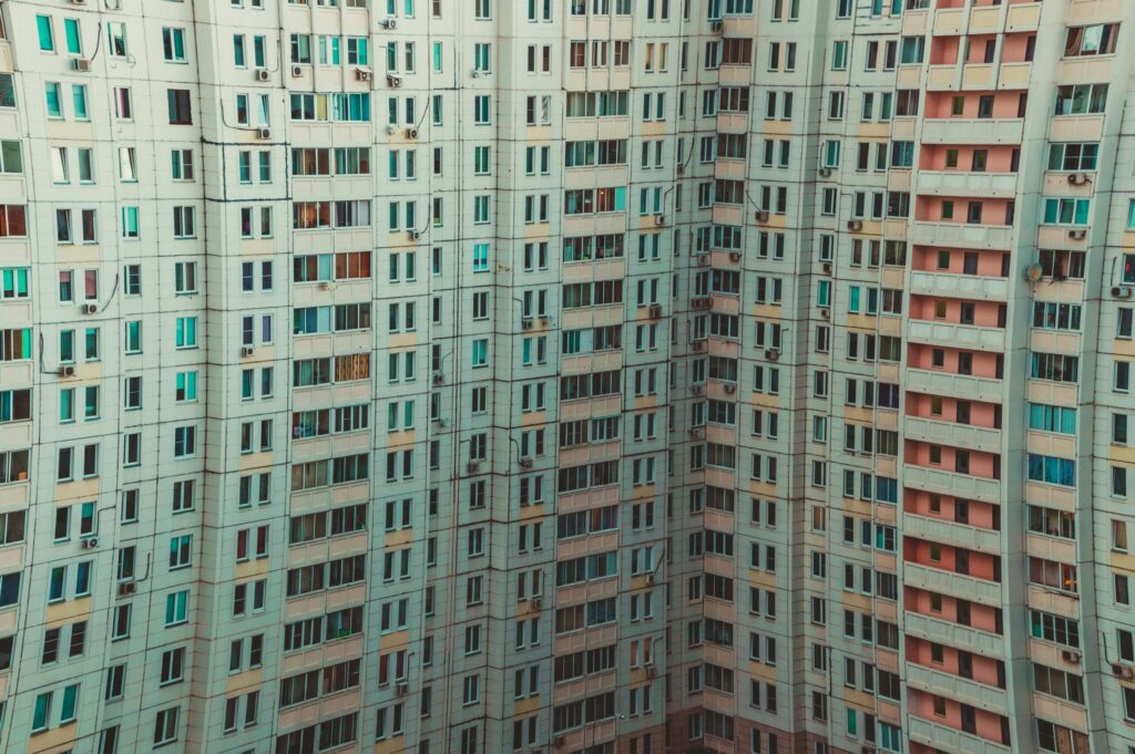 A modern high-rise building with a detailed view of multiple windows and balconies, showcasing urban architecture.